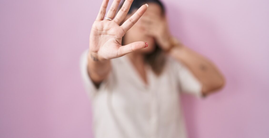 Blonde Woman Standing Over Pink Background Covering Eyes With Hands And Doing Stop Gesture With Sad And Fear Expression. Embarrassed And Negative Concept.