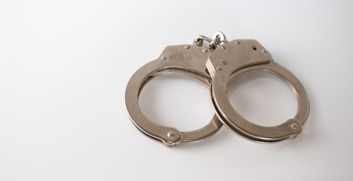 High Angle Shot Of Metal Handcuffs Isolated On A White Background