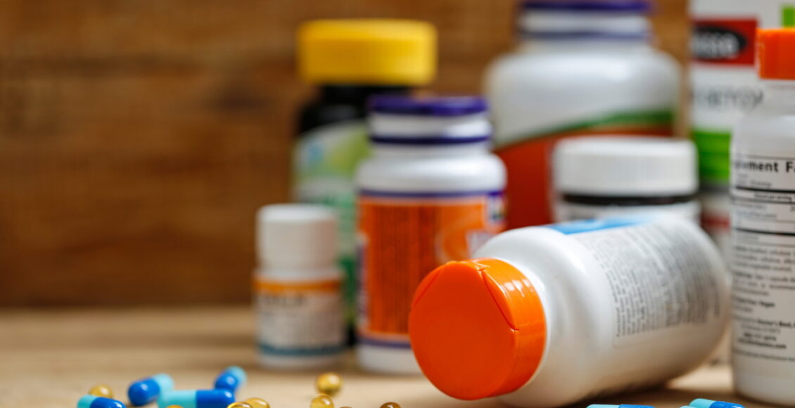 Medicine Bottles And Tablets On Wooden Desk