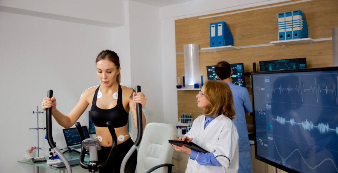 Female Athlete Doing Physical Effort On The Stepper And The Doctor Follows Her