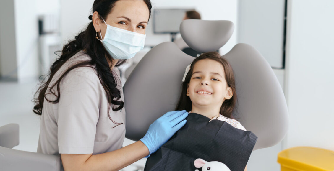 Little Beautiful Girl At The Dentist Looking At The Camera And Smiling