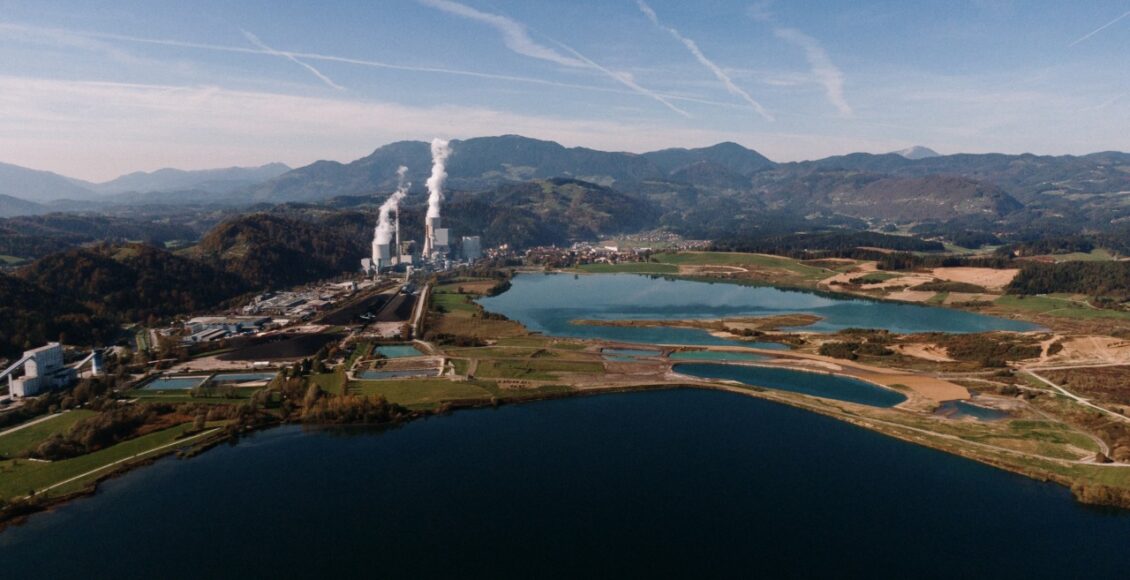 Aerial Shot Of A Landscape Surrounded By Mountains And Lakes With Industrial Disaster