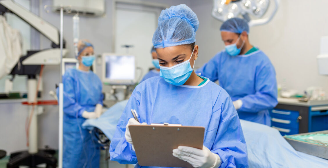 Surgeon Writing On Clipboard In Operation Room, Anaesthesiologist Writing The Updates