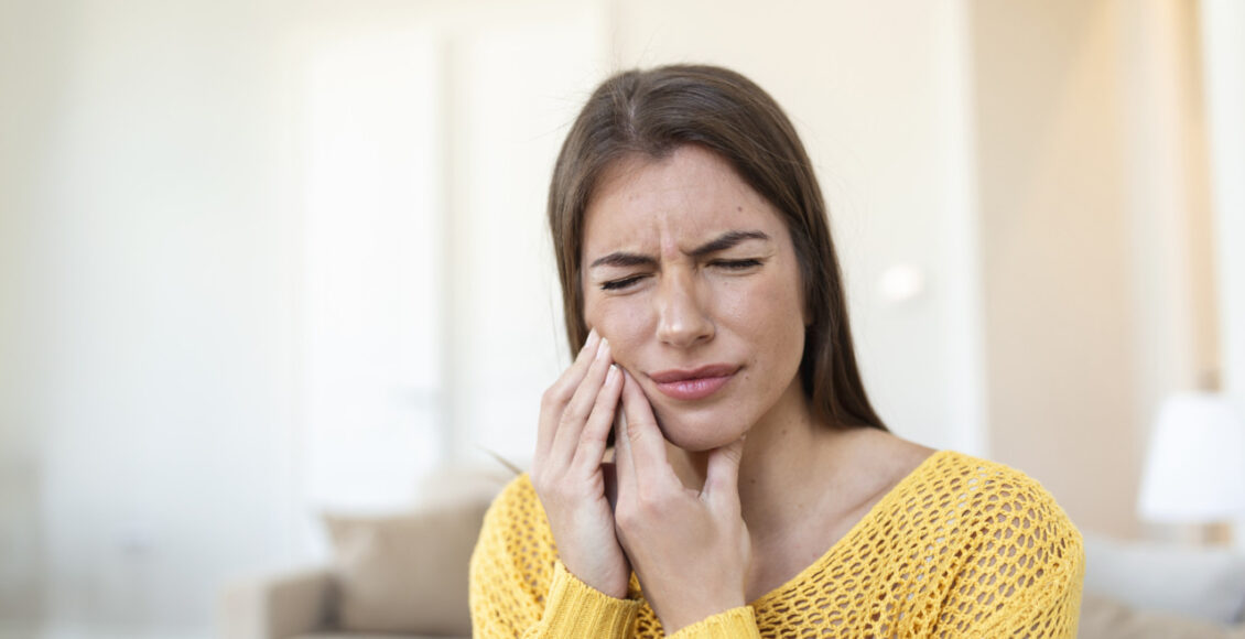 Tooth Pain And Dentistry. Beautiful Young Woman Suffering From Terrible Strong Teeth Pain, Touching Cheek With Hand. Female Feeling Painful Toothache. Dental Care And Health Concept. High Resolution