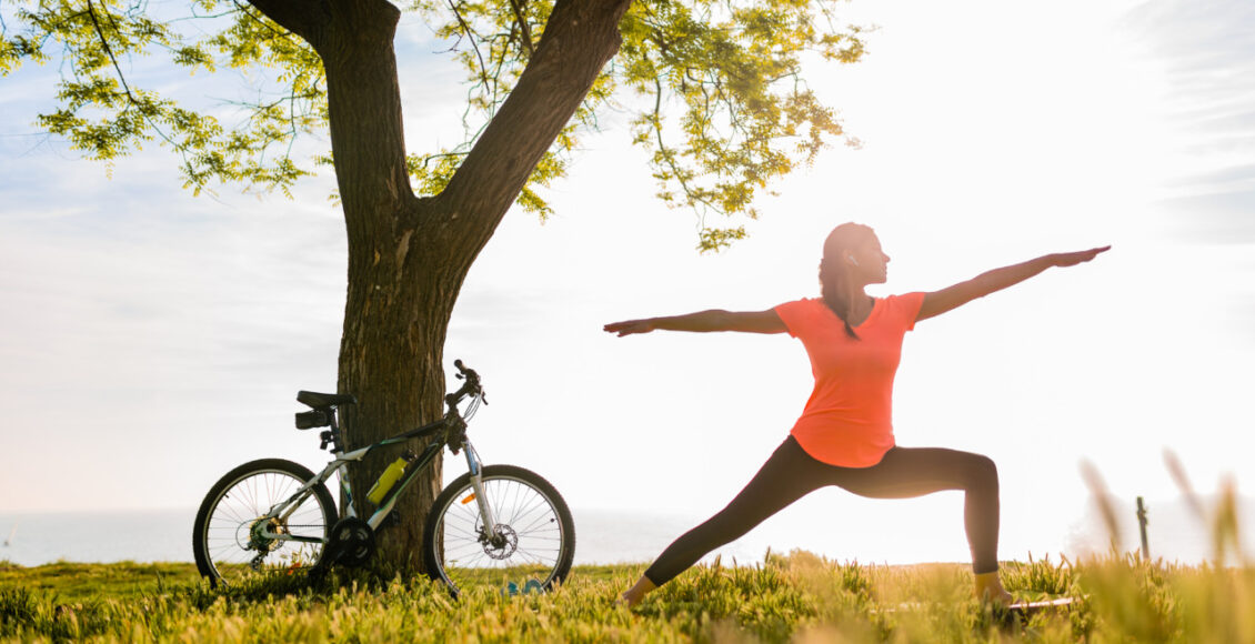 Slim Beautiful Woman Silhouette Doing Sports In Morning In Park Doing Yoga On Mat In Colorful Fitness Outfit In Nature, Smiling Happy Healthy Lifestyle, Calm Meditation, Bicycle On Background