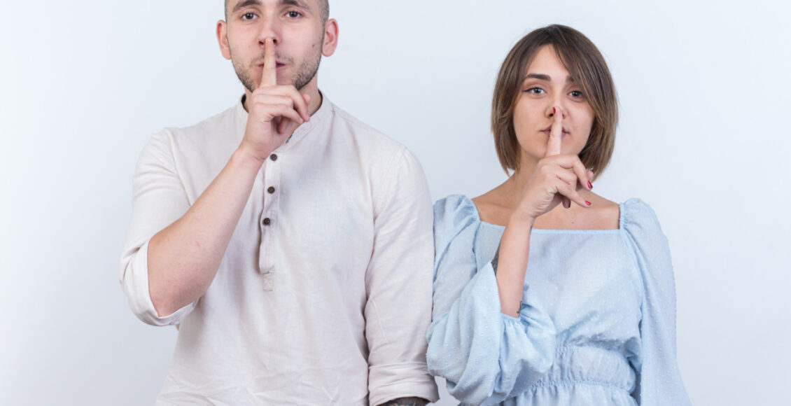 Young Beautiful Couple In Casual Clothes Man And Woman Looking At Camera Making Silence Gesture With Fingers On Lips Standing Over White Background