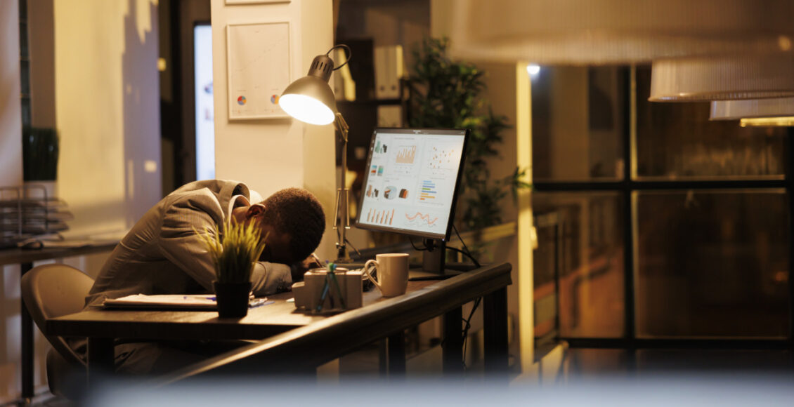 Tired Drained Entrepreneur Sleeping On Desk In Startup Office