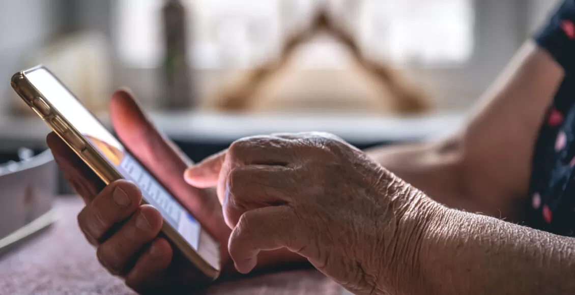 Hands Of An Elderly Woman Holding A Mobile Phone.