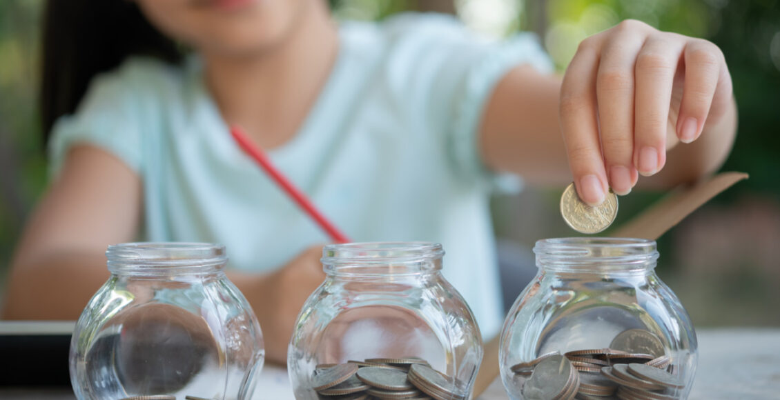 Cute Asian Little Girl Playing With Coins Making Stacks Of Money
