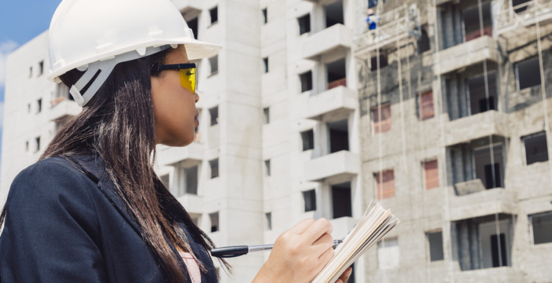 Americano Africano Senhora Em Capacete Seguranca Escrita Em Notepad Perto Predios Construcao