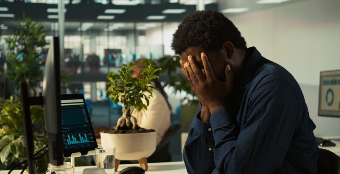 Overworked Man Having Migraine Symptoms While Working On Pc, Drinking Water